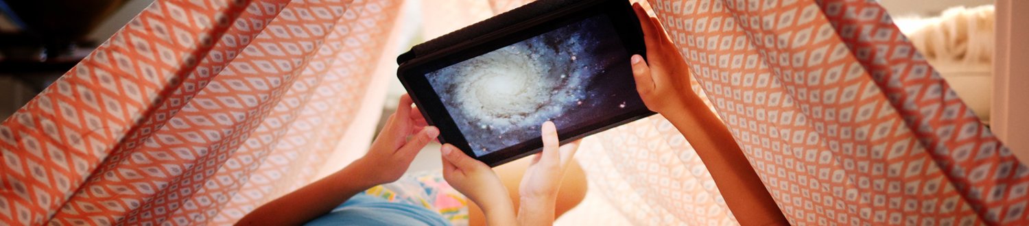 Children holding up tablet with solar system on it