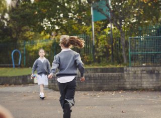 Getty image - one school child running towards another outside