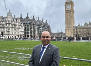 Professor Prashant Kumar stands in front of the Palace of Westminster, Parliament. 