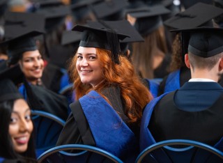 Surrey graduand turning around in graduation ceremony audience