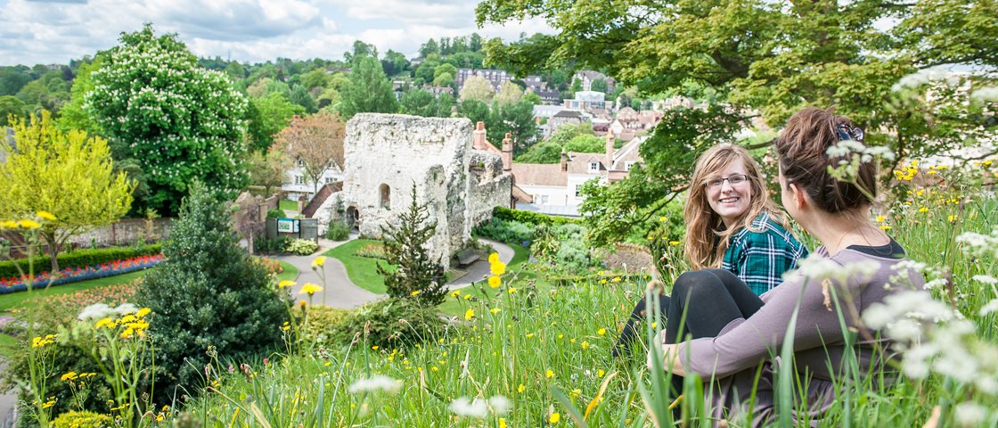 Two students sat on a hill by Guildford Castle