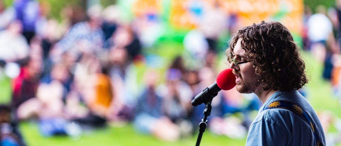 Male singing into red microphone