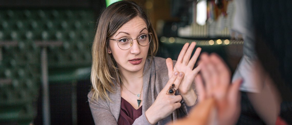 Woman using sign language to communicate in a cafe