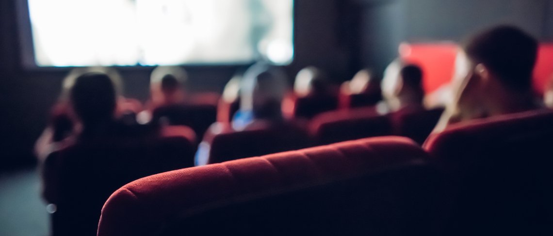 An audience in a cinema watching a film