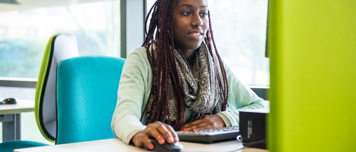 Female student using the computer at the library