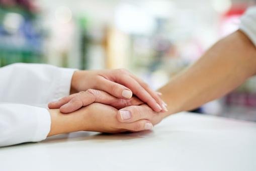 A young lady holding the hand or an older cancer patient