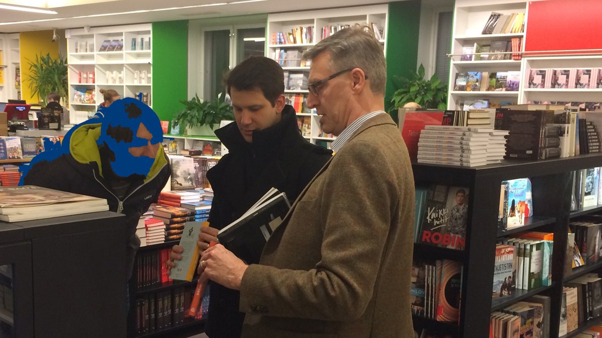 Three men standing in bookshop