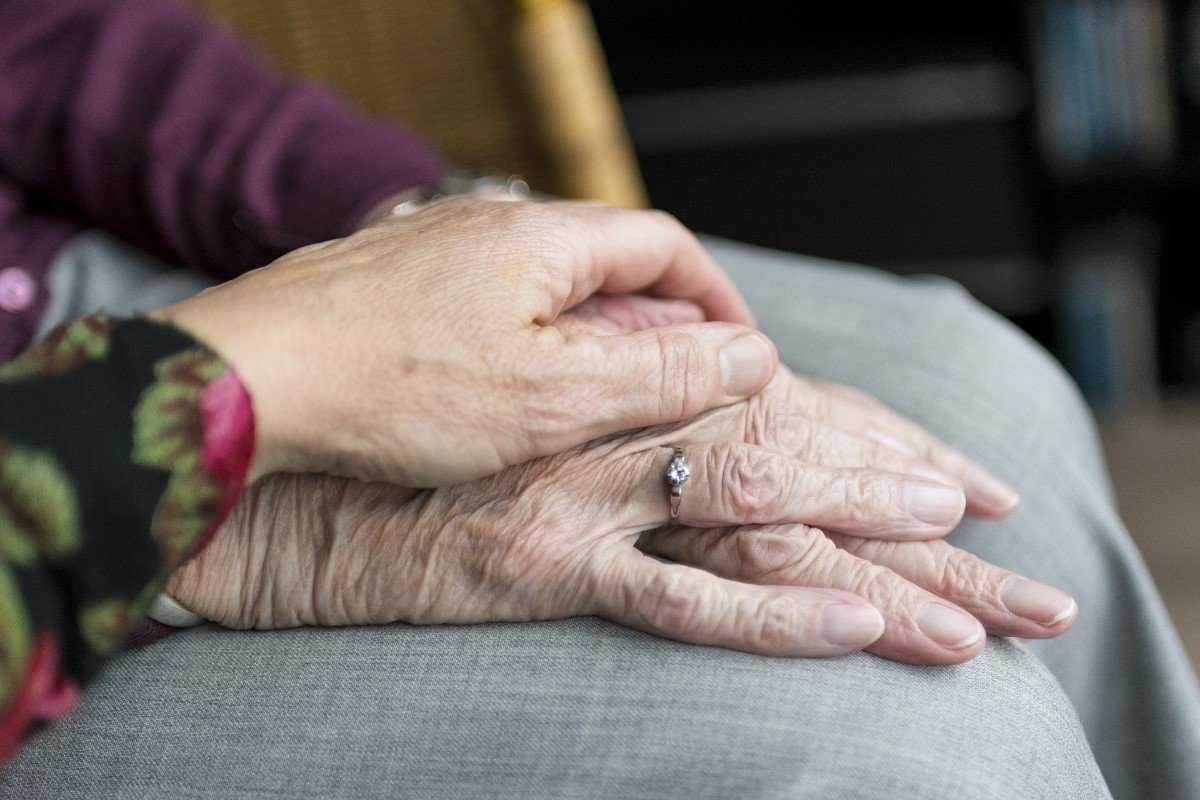Carer holding hand of an elderly woman