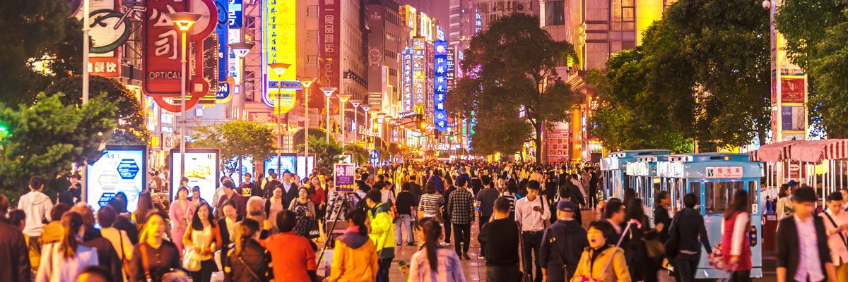 Crowds of people walking through city at night