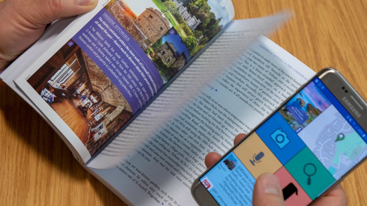 Somebody uses a mobile phone to interact with an augmented travel guide