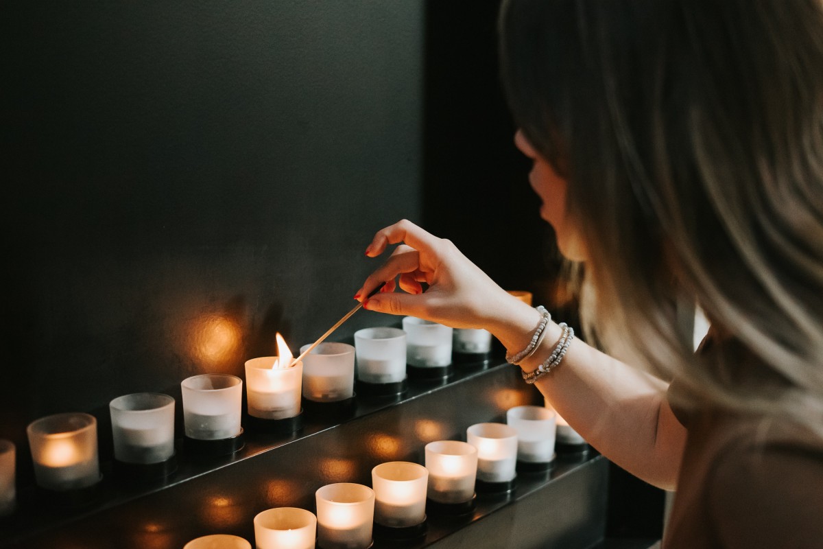 Woman lighting candle for Holocaust Memorial Day