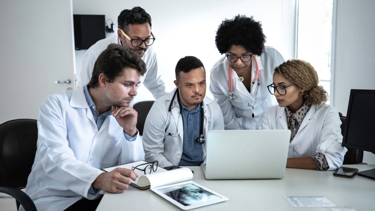 Group of doctors gathered around a laptop