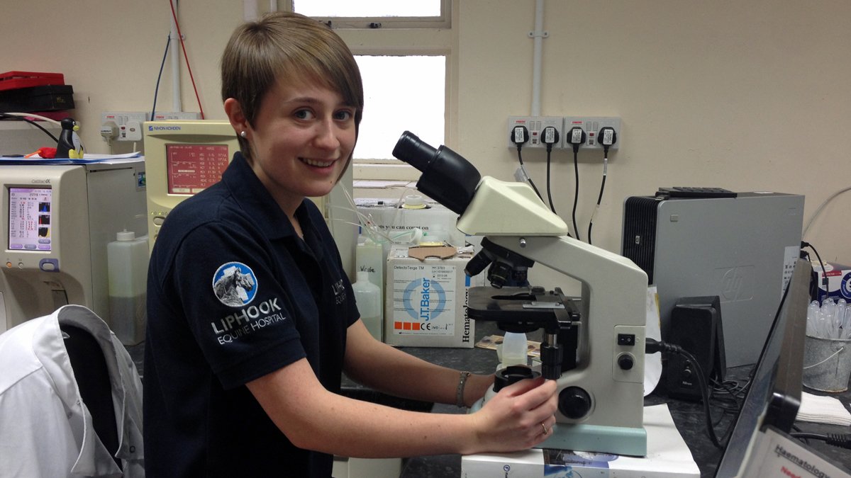 Student Emma Clayton sitting in front of a microscope
