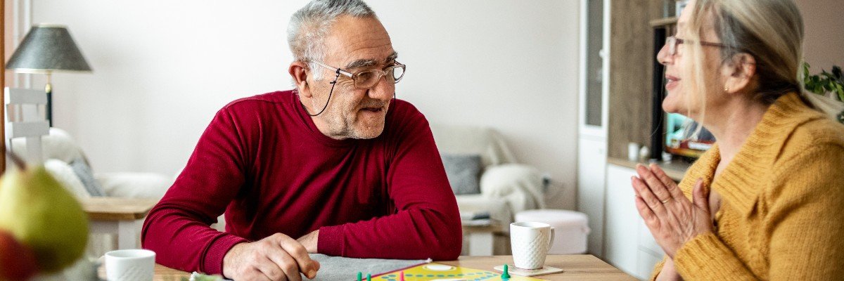 Two elderly people play a board game together