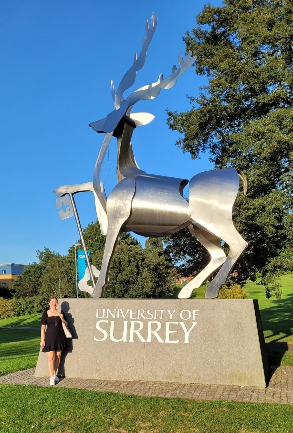 PhD student Beyza Ucar standing by stag statue at University of Surrey