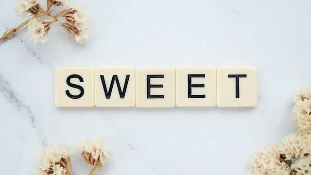 SWEET spelled out in scrabble letters on white floral background - copyright Pixabay