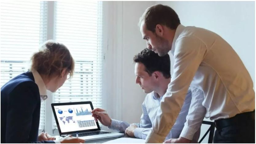 Economics students looking at computer screen