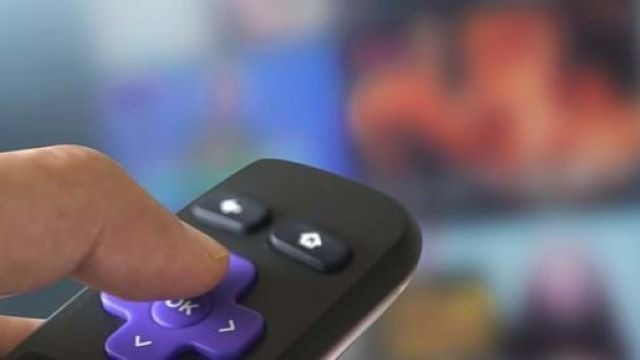 Finger pressing on TV remote control