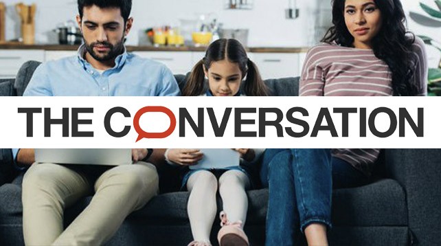 Man, woman and child sat on sofa. Text overlay: The Conversation logo