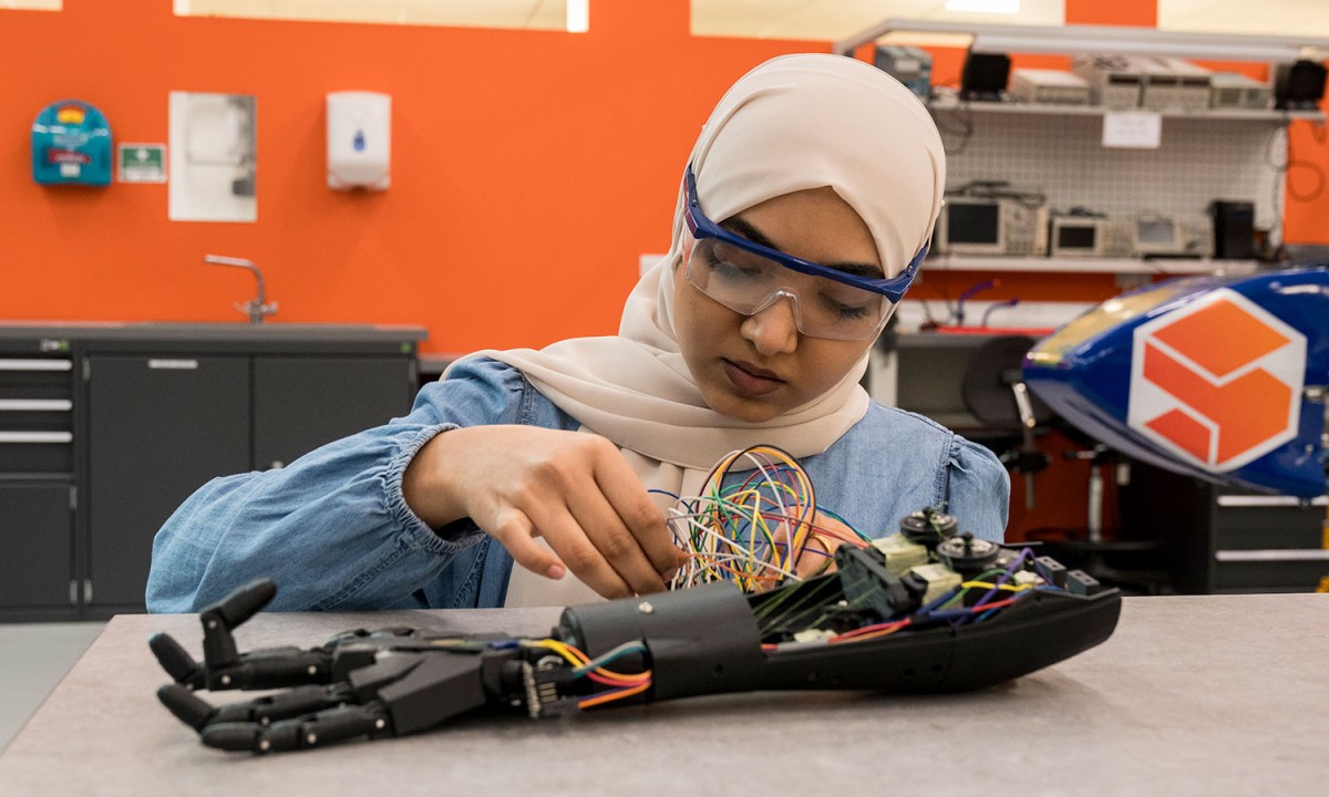 Biomedical engineering student fixing robotic arm