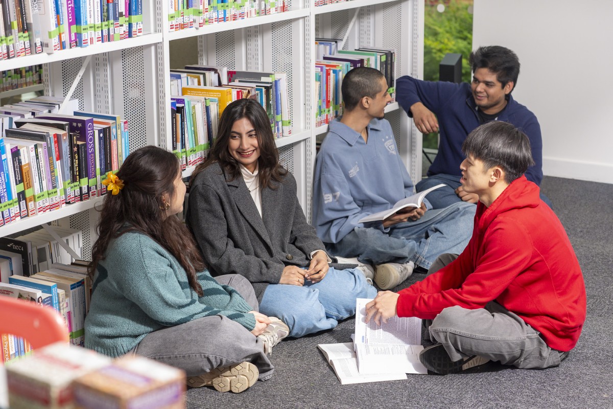 Univeristy of Surrey students sitting on floor of library