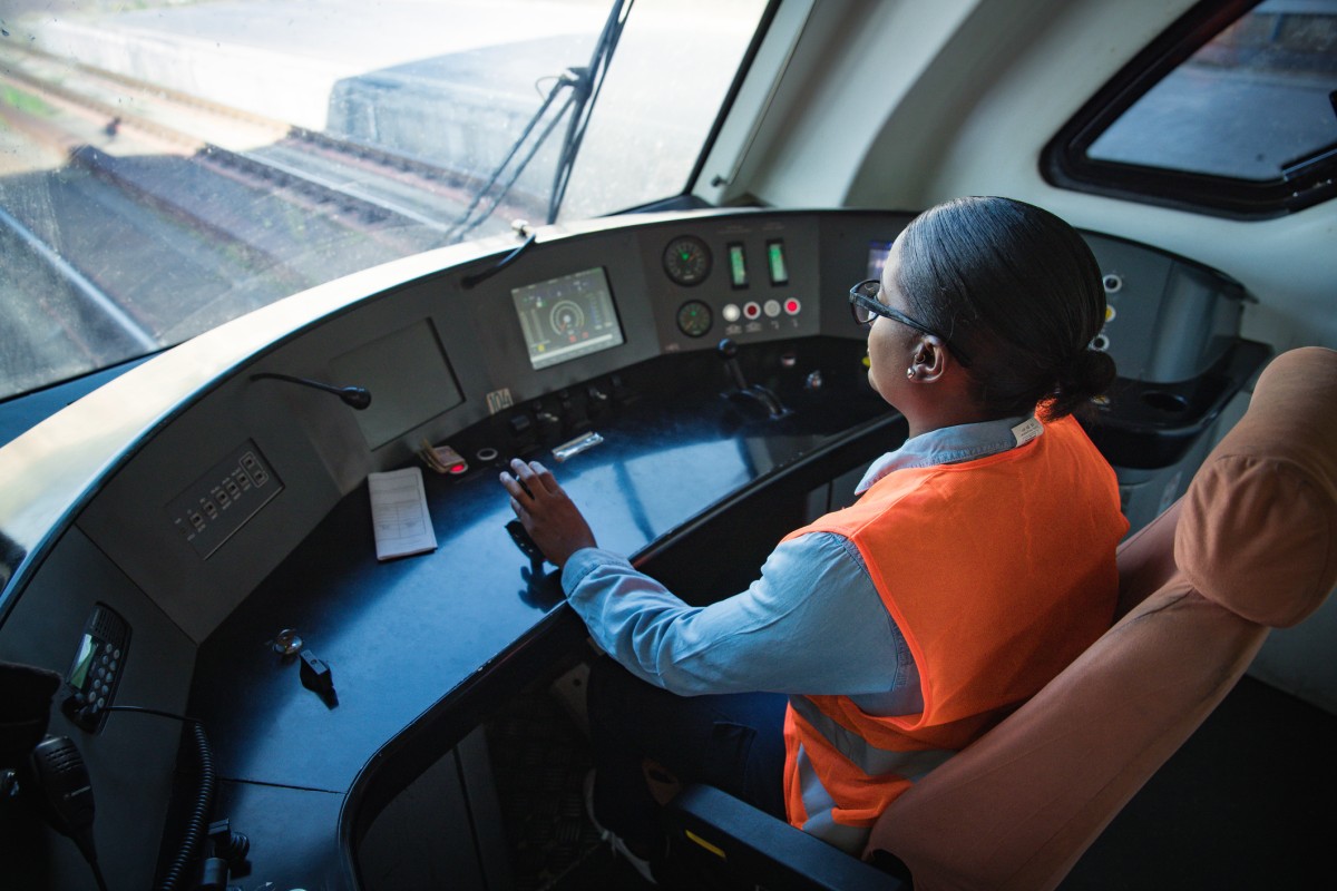 woman in orange hi vis jacket driving train