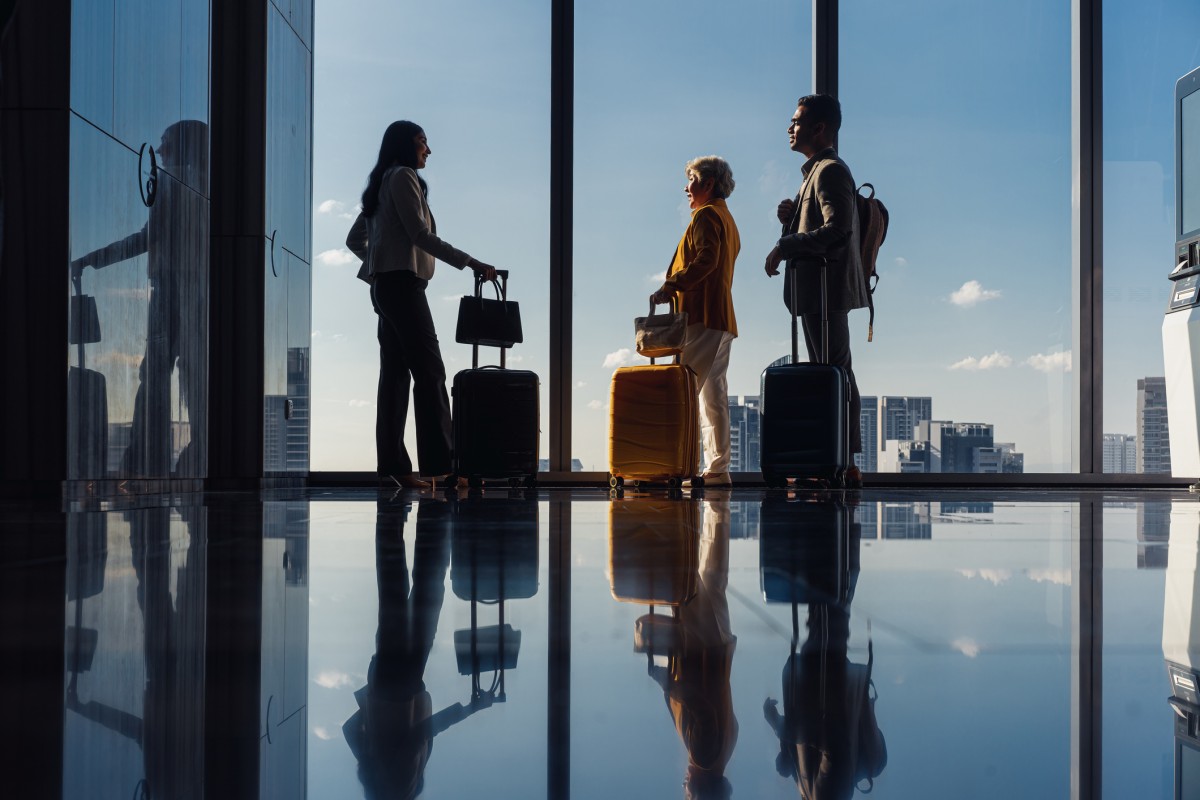 three people with suitcases in a hotel