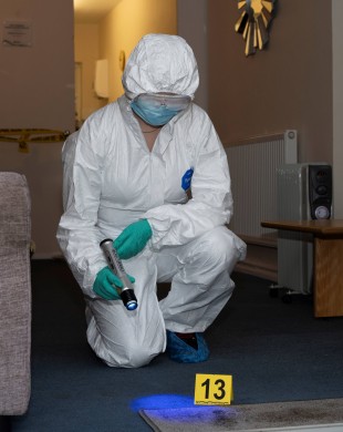 Student using crime lite in our crime scene flat