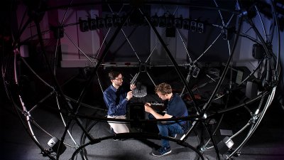 Two men adjusting the sound sphere facility equipment