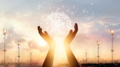 Hands holding up a bubble with the sun setting in the background