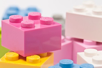 A close up of a pile of pink, blue, yellow and white Lego blocks