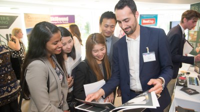 Group of students talking to prospective employer