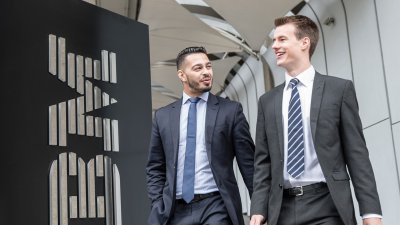 Two students in suits standing by an IBM sign