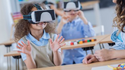 School children wearing virtual reality headsets