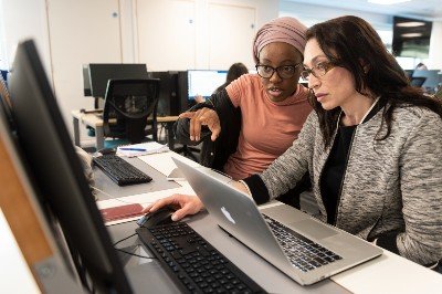 Students study together around a computer