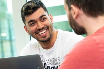 Students study together around a computer 