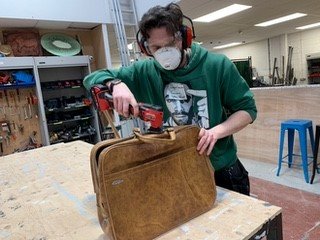 GSA postgrad student, Matt Rudkin, removing suitcase handles for puppetry