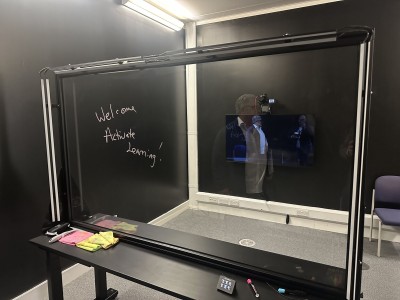 A hand-written welcome to Active Learning notice on a digital board for its visit to the University of Surrey