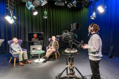 Studio with camera operator filming two men