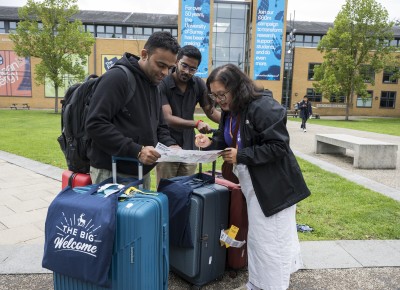 Parents and students on campus with suitcases