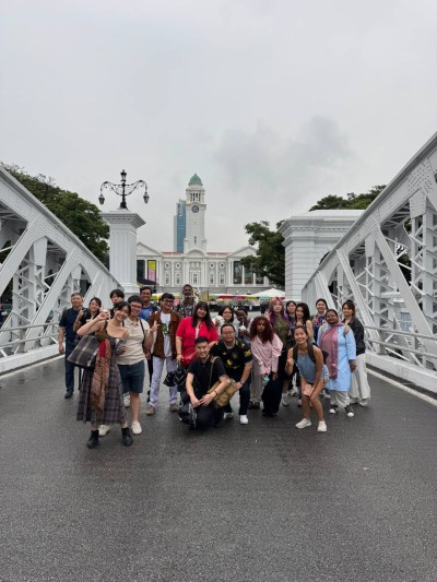 A group of people pose on the Cavenagh Bridge in Singapore.