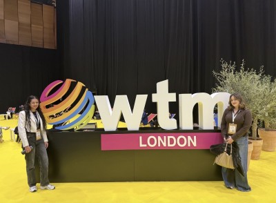 Two students stand at WTM, a professional event