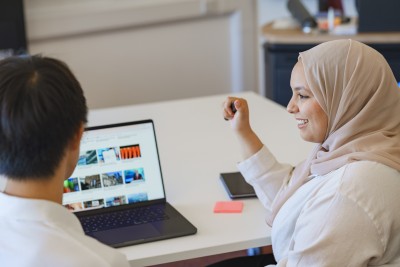 Postgraduate accounting and finance students at the University of Surrey sitting at a desk with a laptop