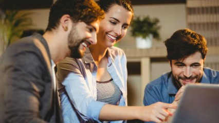 Three people looking at laptop screen