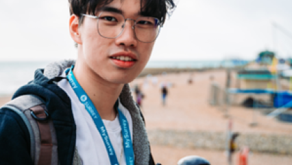 Jian He Low headshot, in background a beach.