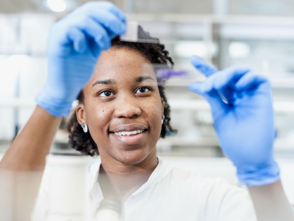 Woman holding up petri dish samples