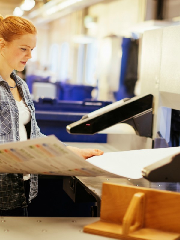 Woman holding industrial size sheet of paper.