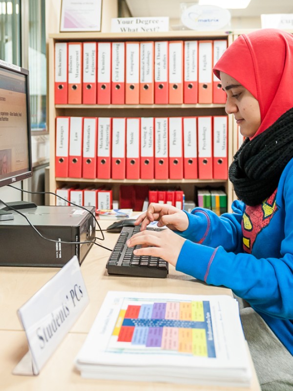 Female student sitting at a PC.