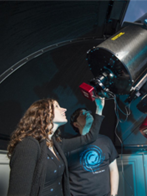 Woman using a large telescope