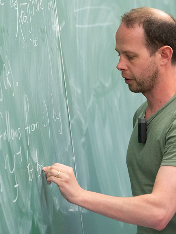 Lecturer writing on chalk board